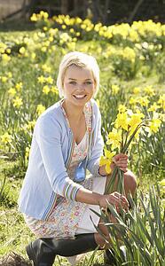 Young Woman Picking Spring Daffodils