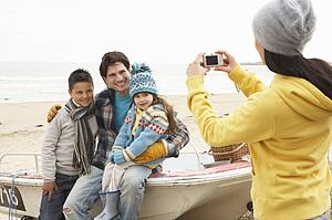 Mother Taking Family Photograph On Winter Beach