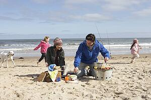Family Having Barbeque On Winter Beach