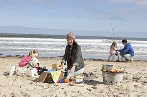 Family Having Barbeque On Winter Beach