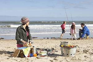 Family Having Barbeque On Winter Beach