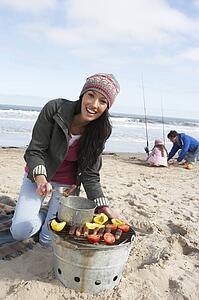 Family Having Barbeque On Winter Beach