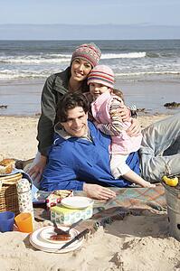 Family Having Barbeque On Winter Beach