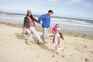 Family Walking Along Winter Beach