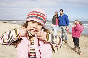 Family Walking Along Winter Beach