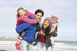 Family Walking Along Winter Beach