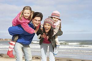 Family Walking Along Winter Beach