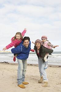 Family Walking Along Winter Beach