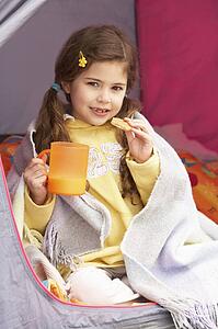Young Girl Relaxing Inside Tent On Camping Holiday