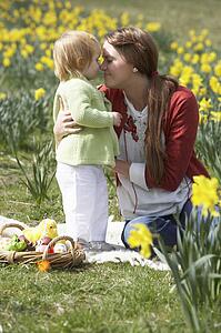 Mother And Daughter In Daffodil Field With Decorated Easter Eggs