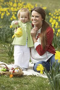 Mother And Daughter In Daffodil Field With Decorated Easter Eggs