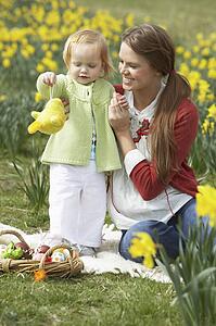 Mother And Daughter In Daffodil Field With Decorated Easter Eggs