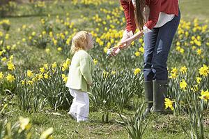 Mother And Daughter In Daffodil Field With Decorated Easter Eggs