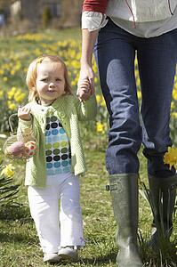 Mother And Daughter In Daffodil Field With Decorated Easter Eggs