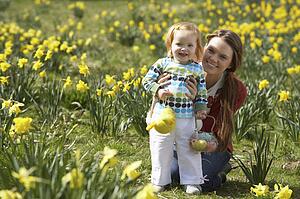 Mother And Daughter In Daffodil Field With Decorated Easter Eggs