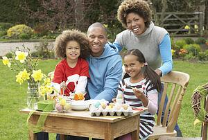 Family Painting Easter Eggs In Gardens