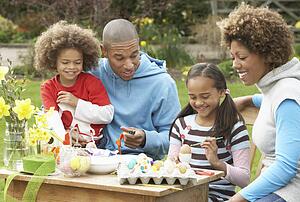 Family Painting Easter Eggs In Gardens