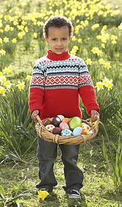 Boy On Easter Egg Hunt In Daffodil Field
