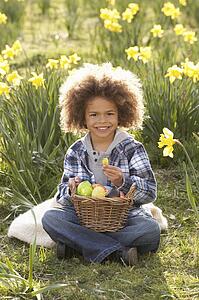Boy On Easter Egg Hunt In Daffodil Field