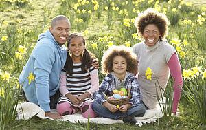 Family Relaxing In Field Of Spring Daffodils