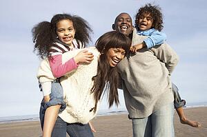 Family Having Fun On Winter Beach