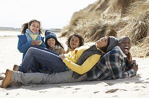Family Sitting On Winter Beach