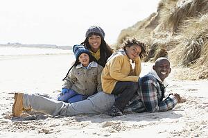 Family Sitting On Winter Beach