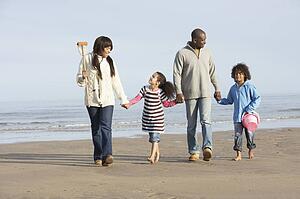 Family Walking By Sea On Winter Beach