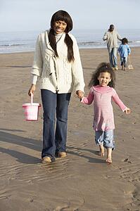Family Walking By Sea On Winter Beach