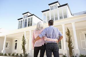 Senior Couple Standing Outside Dream Home