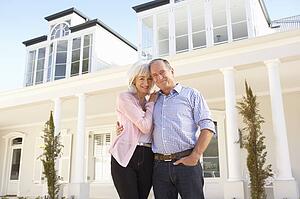 Senior Couple Standing Outside Dream Home