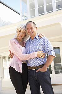 Senior Couple Standing Outside Dream Home