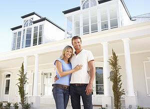 Young Couple Standing Outside Dream Home