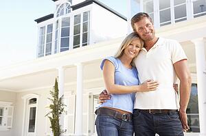 Young Couple Standing Outside Dream Home