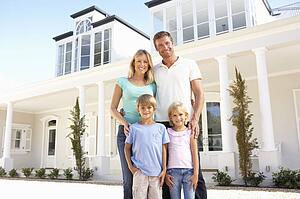 Young Family Standing Outside Dream Home