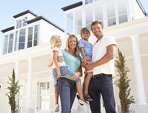 Young Family Standing Outside Dream Home