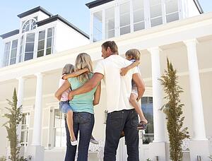 Young Family Standing Outside Dream Home