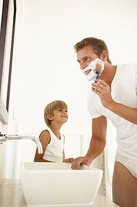 Son Watching Father Shaving In Bathroom Mirror