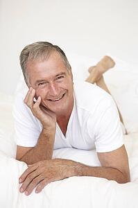 Senior Man Relaxing On Bed