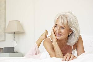 Senior Woman Relaxing On Bed
