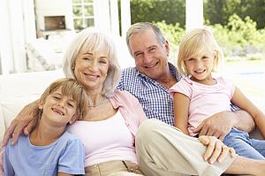Portrait Of Grandparents With Grandchildren Relaxing Together On Sofa