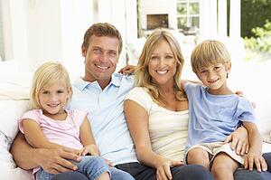 Portrait Of Young Family Relaxing Together On Sofa