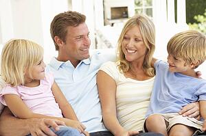 Portrait Of Young Family Relaxing Together On Sofa