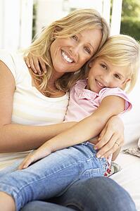 Portrait Of Mother And Daughter Relaxing On Sofa