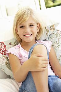 Portrait Of Young Girl Relaxing On Sofa