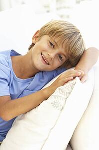 Portrait Of Young Boy Relaxing On Sofa