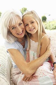 Portrait Of Grandmother With Granddaughter Relaxing Together On Sofa