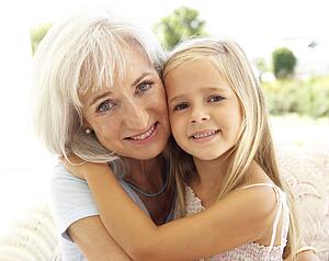 Portrait Of Grandmother With Granddaughter Relaxing Together On Sofa