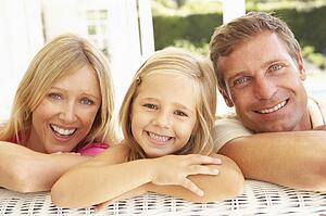 Portrait Of Young Family Relaxing Together On Sofa