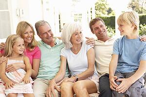 Extended Family Relaxing Together On Sofa